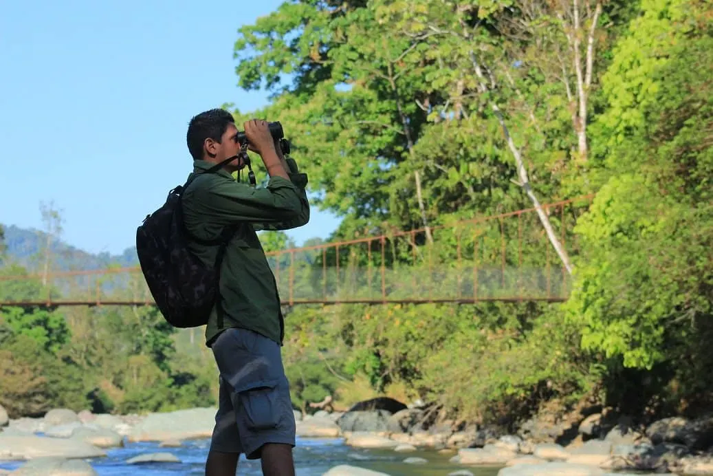 Elías observando la fauna con binoculares en Manuel Antonio