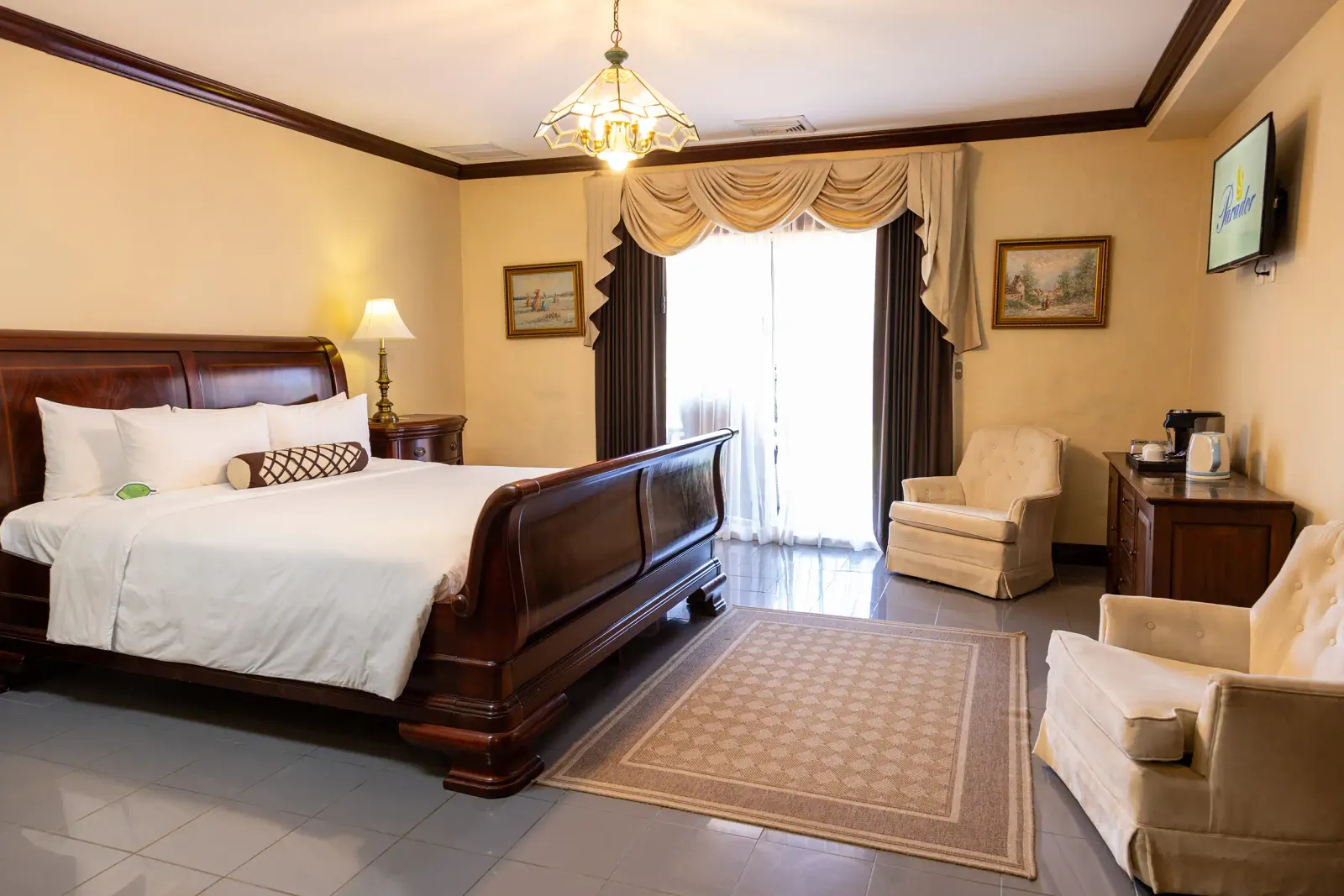 Family Suite master bedroom with a carved sleigh bed, an armchair and a writing desk