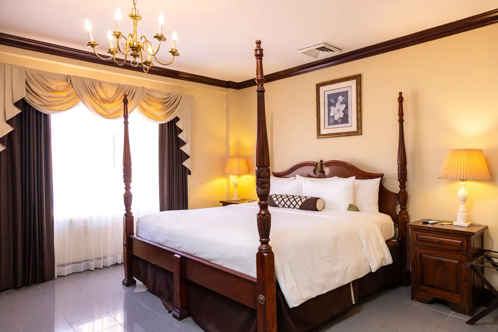 Family Suite bedroom with a four-poster king bed and gold curtains