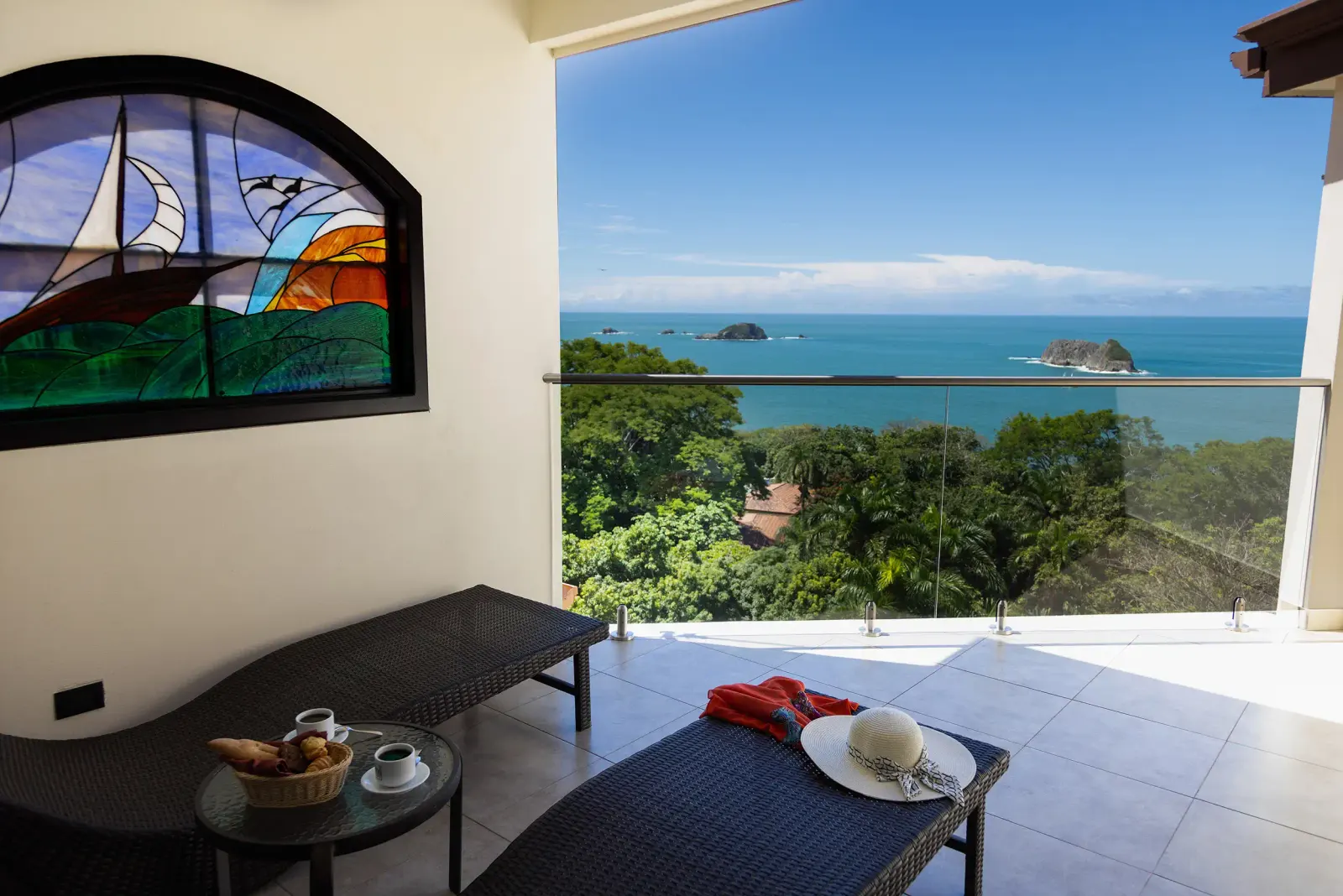 Penthouse terrace under a stained glass window, looking over the forest to the Pacific and the islands