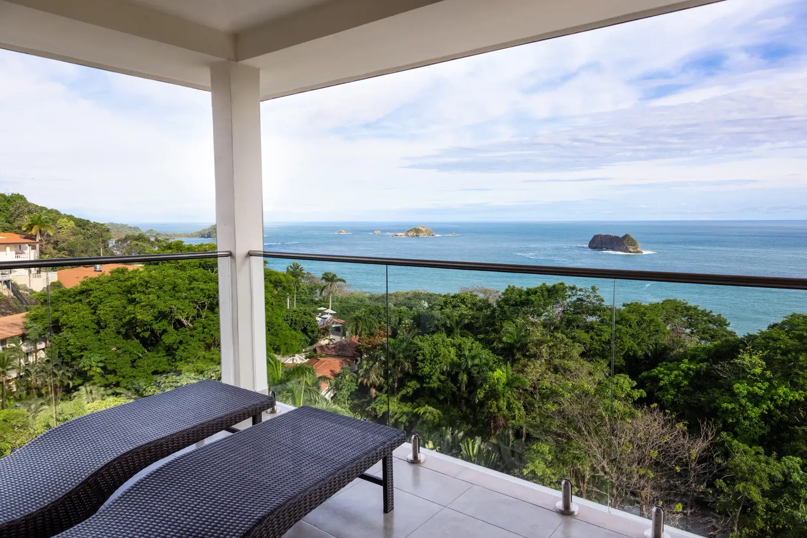 Vista Master Suite balcony with two loungers, looking over the forest to the Pacific and the islands off Manuel Antonio