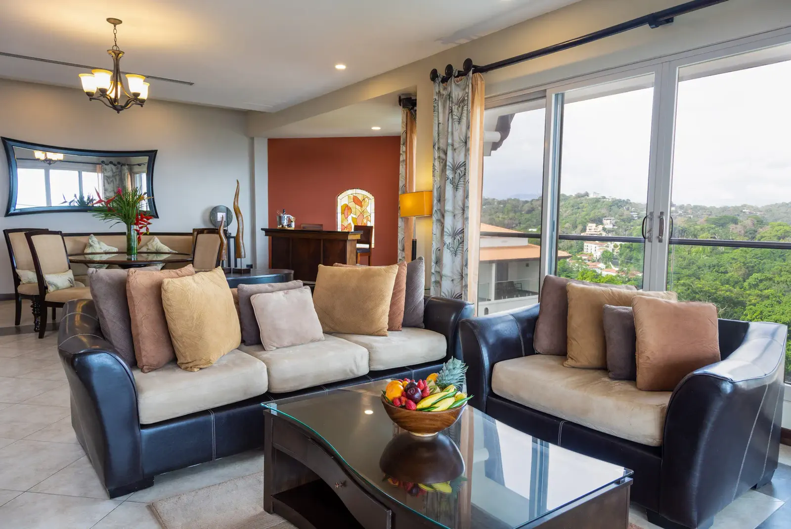 Vista Master Suite living room with leather sofas, a glass coffee table and floor-to-ceiling windows to the sea