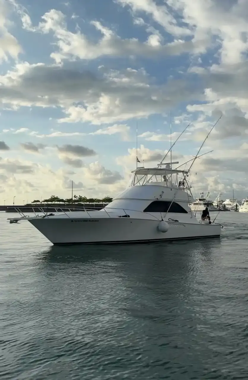 Vuelto Loco, a white Viking sport fisher, at anchor in calm water at sunrise