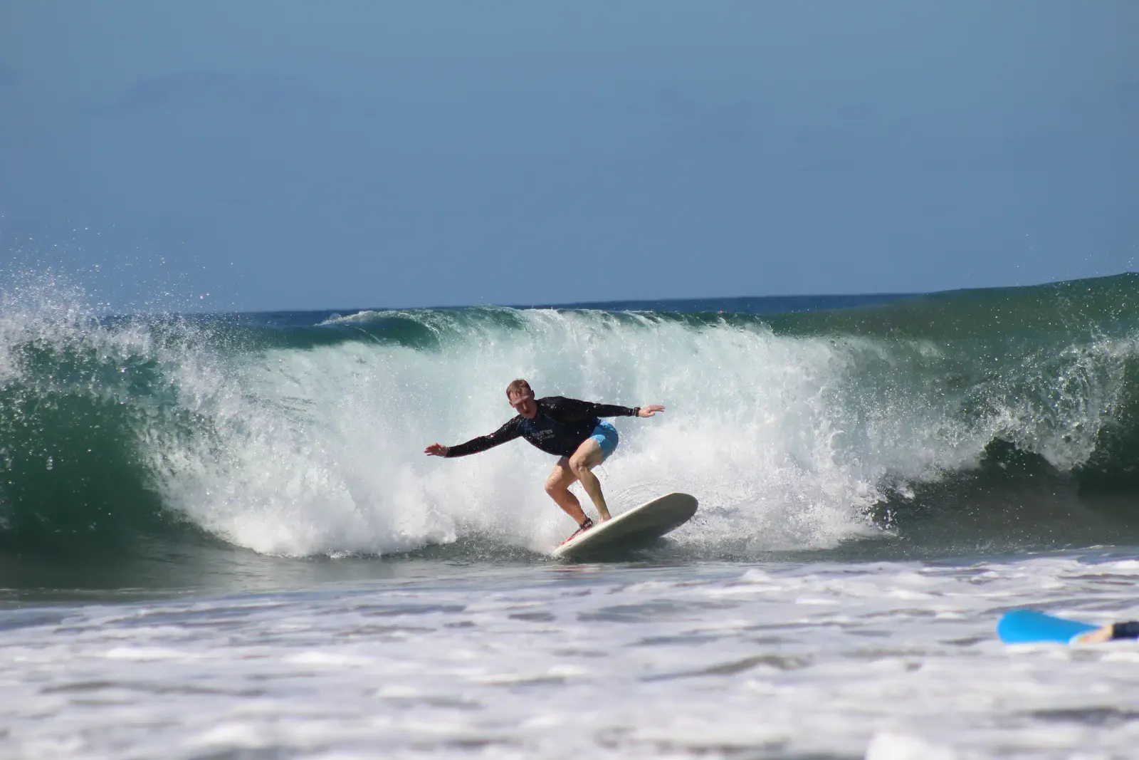 Surfista girando sobre la cara de una ola que rompe