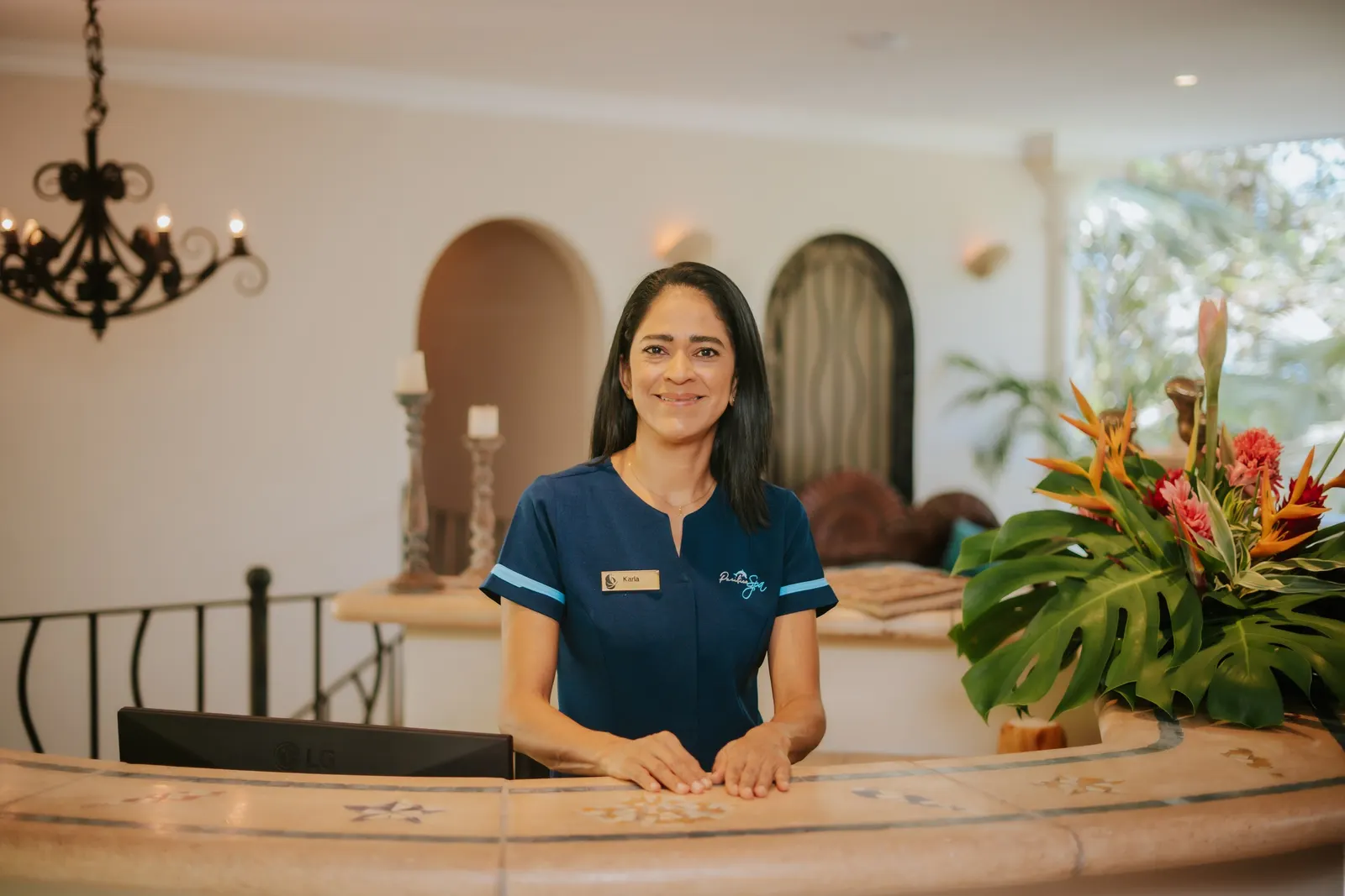 A Pacífica Spa host smiling at the reception desk