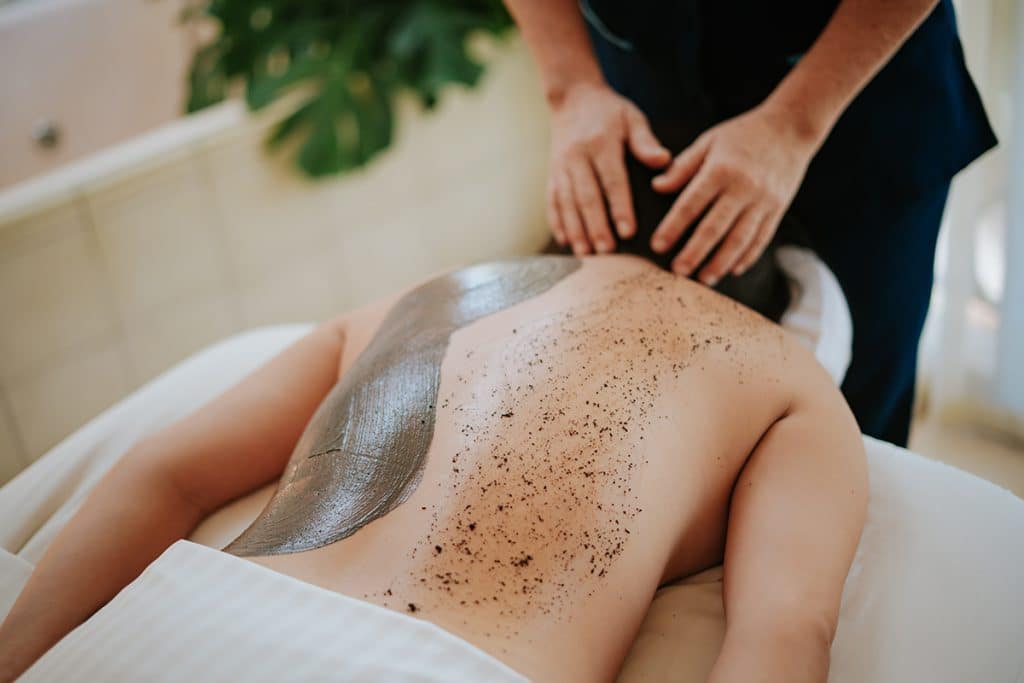 Body scrub being applied on a massage table