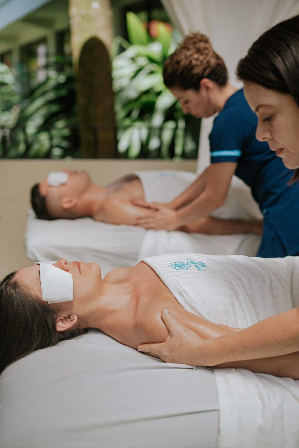 Two guests receiving massages side by side