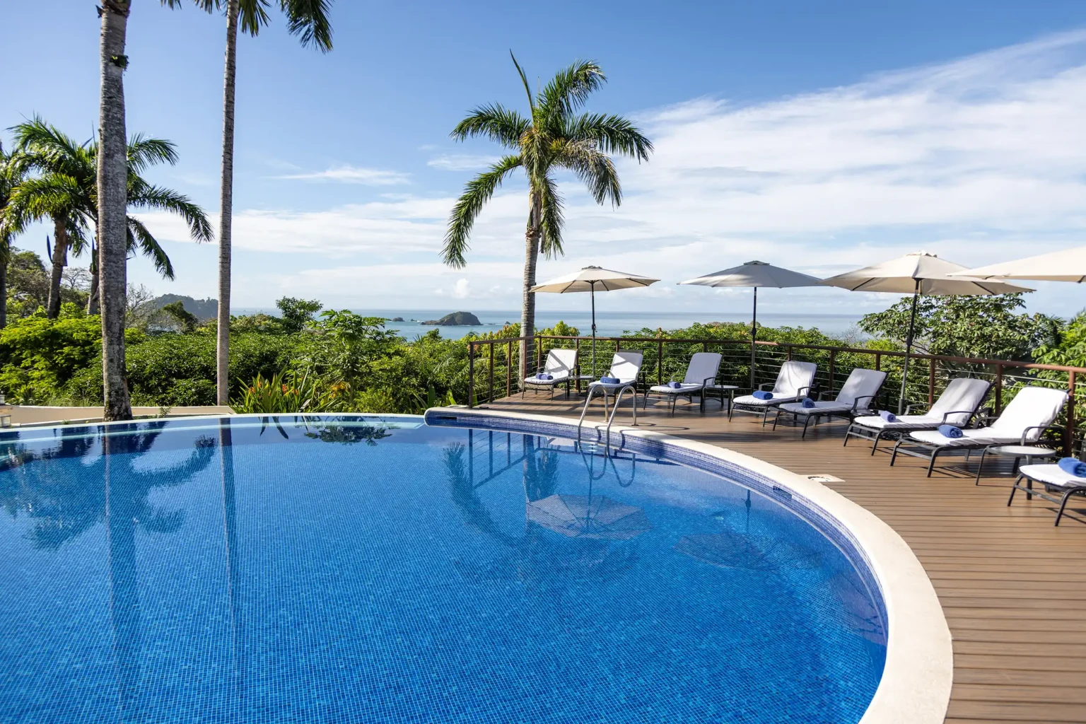 Main pool with sun loungers and umbrellas above the Pacific