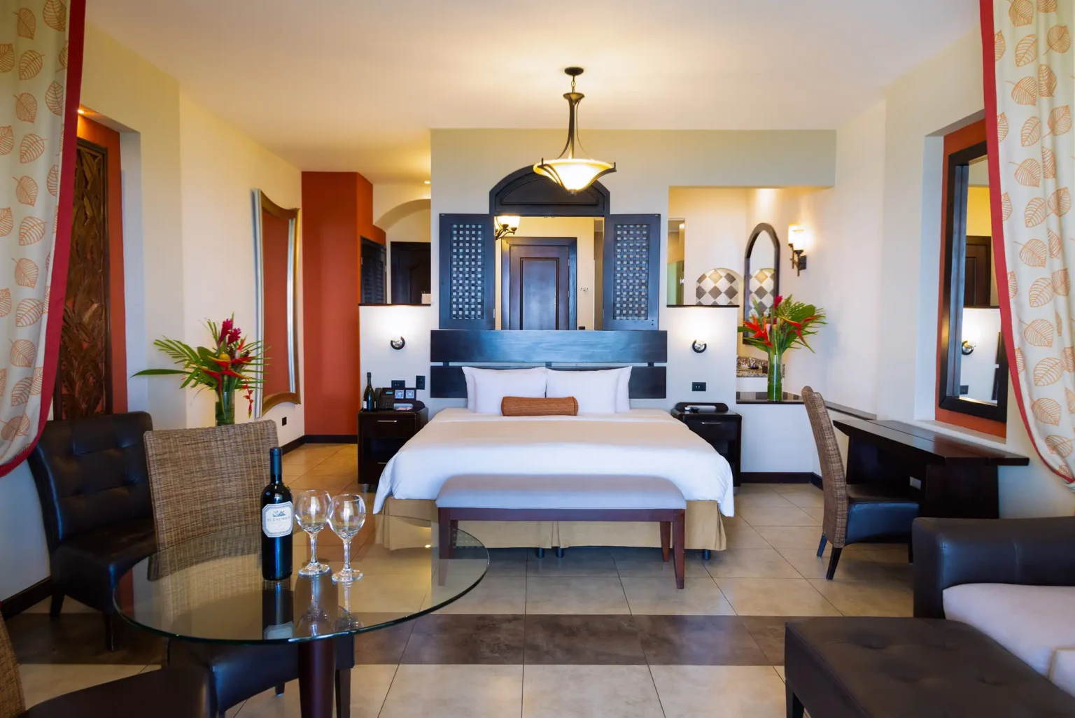 Vista Suite interior with king bed, sitting area and wine on the table