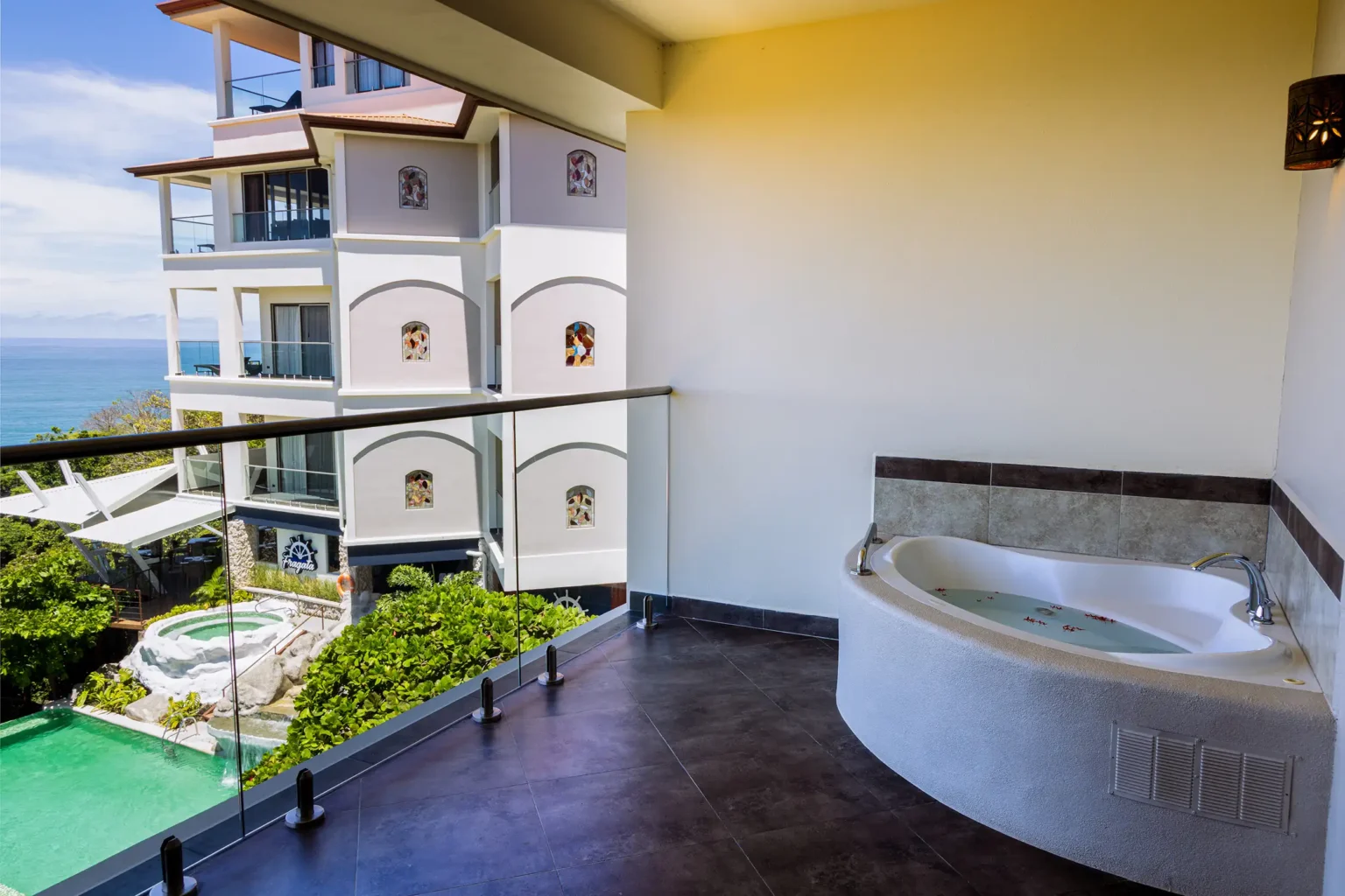 Private balcony hot tub with a view of the hotel tower and pool